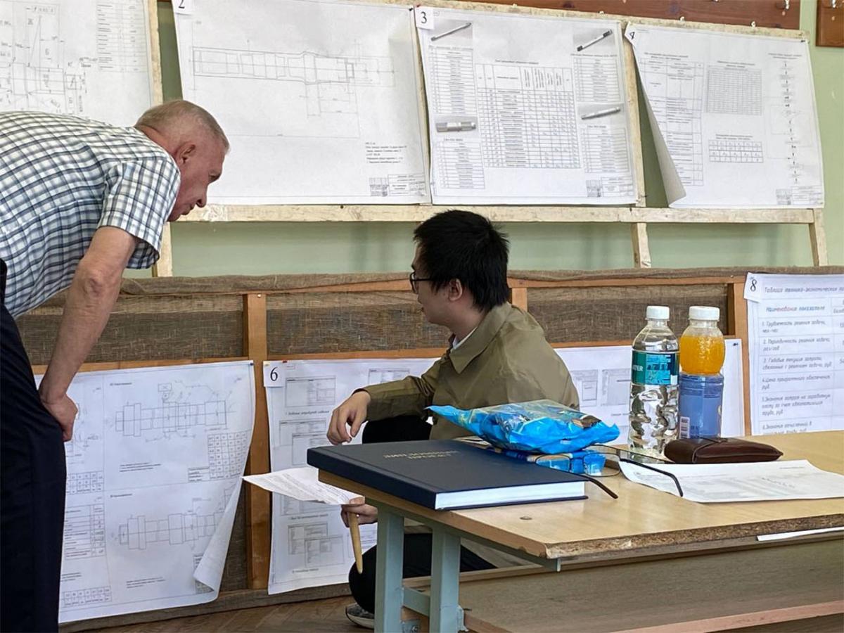 Профессор <em><strong>Ю. В. Синькевич</strong></em> беседует с дипломником по вопросам механической обработки деталей на операциях